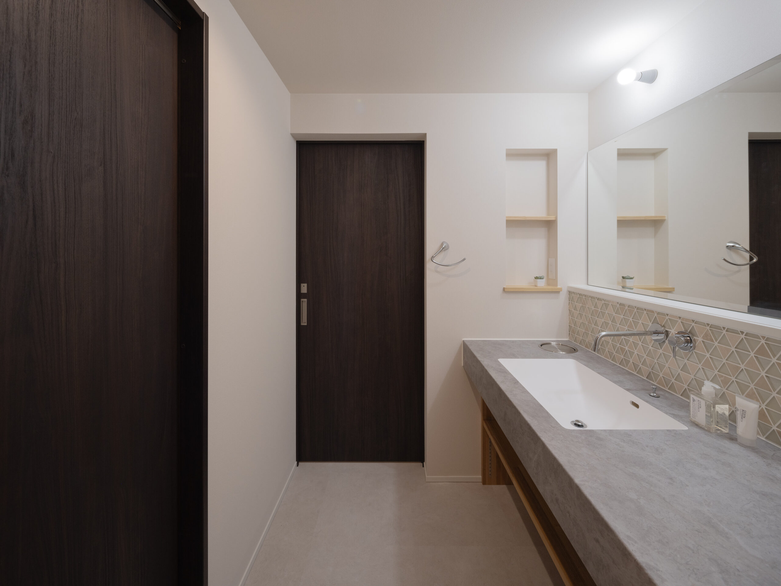 ガラスタイルやスタイリッシュな天板を取り入れた洗面室