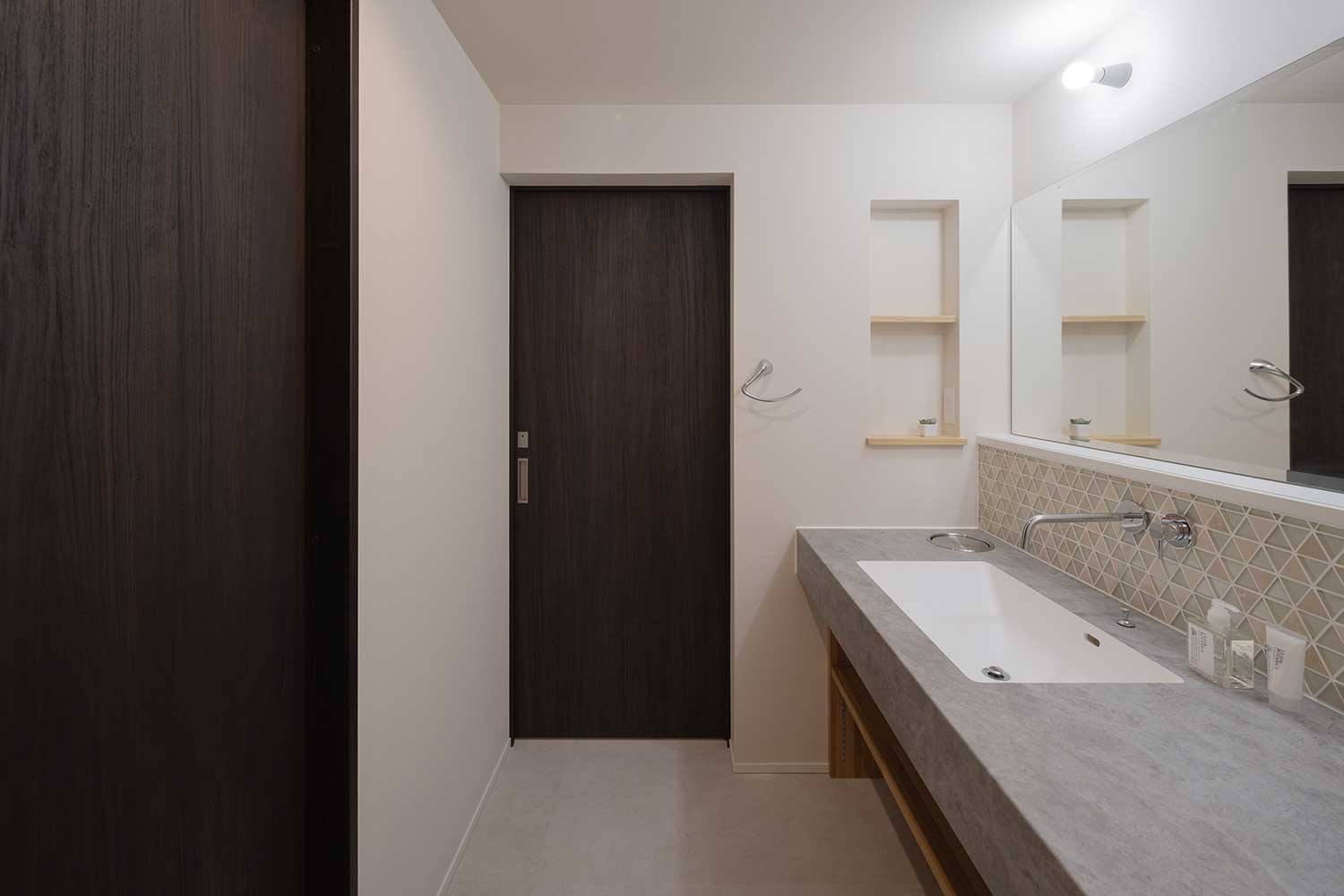 ガラスタイルやスタイリッシュな天板を取り入れた洗面室